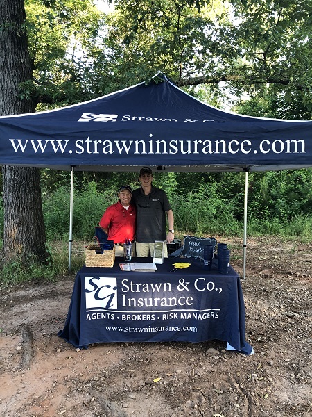 Two agents at the Strawn & Co tent at the Flint River Council Boy Scouts of America Sporting Clay Tournament